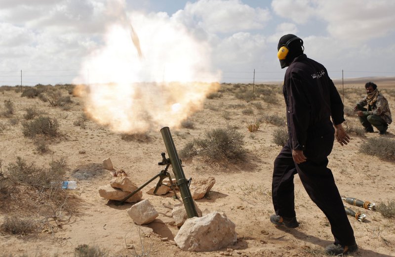 A Libyan rebel shells pro-Gadhafi forces along the front line outside the eastern town of Brega, Libya, on Thursday.