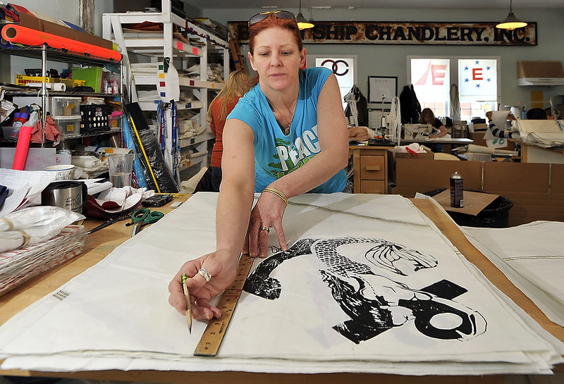 Mary Anne Salmon, a kidder, prepares the sail panel for the seamstresses by “kidding” or marking where the panels are stitched together, for the final product. This particular panel has been silkscreened with a pattern, one of many series of Seabags with added designs.