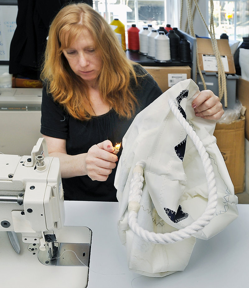 Seamstress Lisa Ricks burns the ends of the heavy-duty sail thread to lock in the stitches after making this anchor-themed bag at Seabags in Portland. Full-size totes sell for $100 to $150.