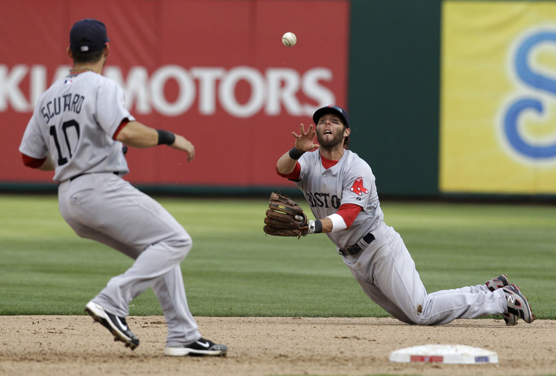 Dustin Pedroia of the Boston Red Sox flips the ball to shortstop Marco Scutaro for a force play at second in the seventh inning Friday. The Red Sox fell to the Texas Rangers, 9-5.