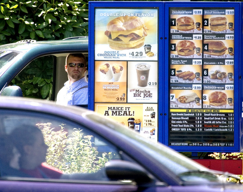 Drive-through customers view the menu at a Burger King in Portland, Ore. Restaurant chains with 20 or more locations will soon be required to clearly post on their menus the amount of calories for each item they sell.