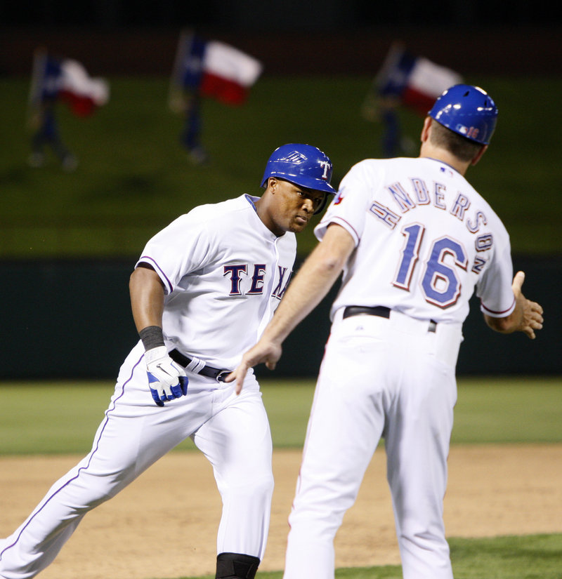 Adrian Beltre of the Texas Rangers receives the way-to-go from third-base coach Dave Anderson after hitting a grand slam Saturday night against the Boston Red Sox.