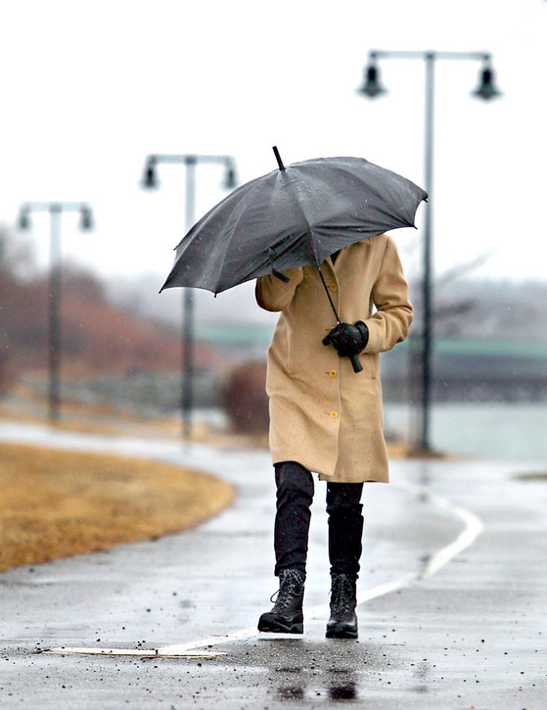 Sara Levite of Cumberland battles wind and sleet as she walks along the Eastern Prom Trail in Portland on Monday. Levite, who works in Portland, was out for some fresh air. Today will be drier with highs near 50.