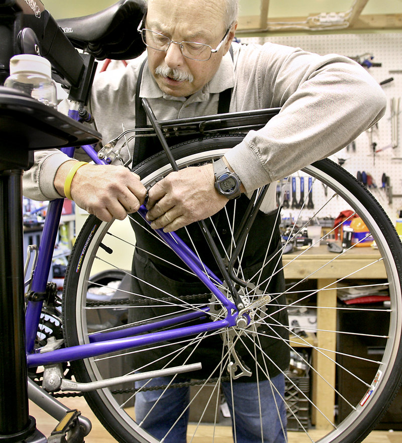 Morin sets the rear brakes to make sure the brake pads will meet the rim at the same time as he does spring maintenance on a touring bike at his shop last week.