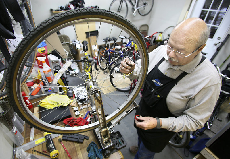 Jerry Morin, owner of Jerry’s Bike Barn in Berwick, uses a truing stand to check whether a wheel is straight.