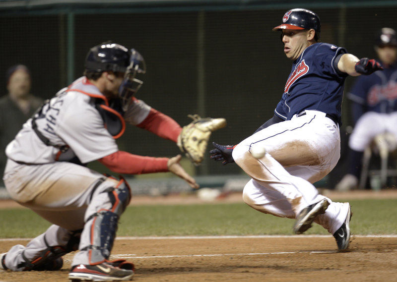 Asdrubal Cabrera of the Cleveland Indians slides safely to the plate, scoring on a sacrifice fly as Boston catcher Jarrod Saltalamacchia waits for the throw Tuesday.