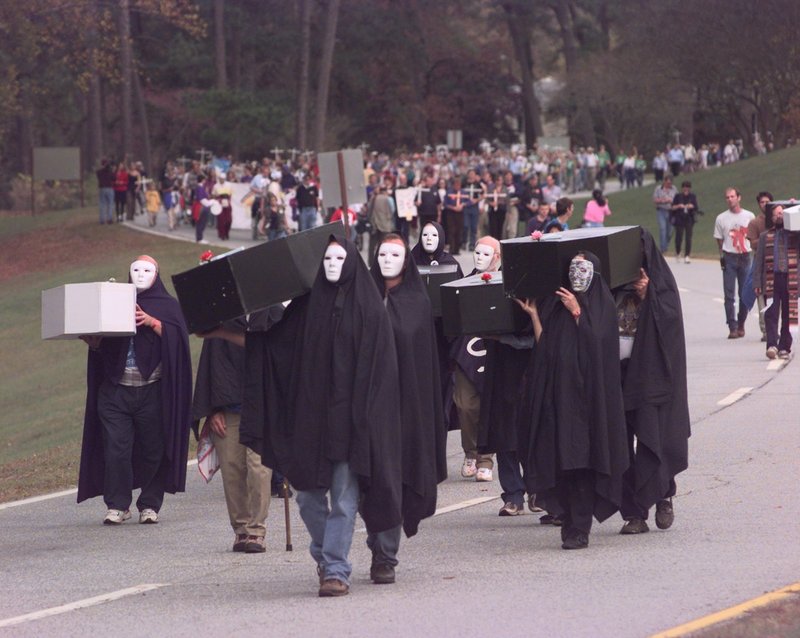 Protesters dressed as corpses lead a procession at Fort Benning, Ga., in 1999. The Rev. Roy Bourgeois is among those who say human rights abuses have been committed by graduates of the Army’s School of the Americas at the post.