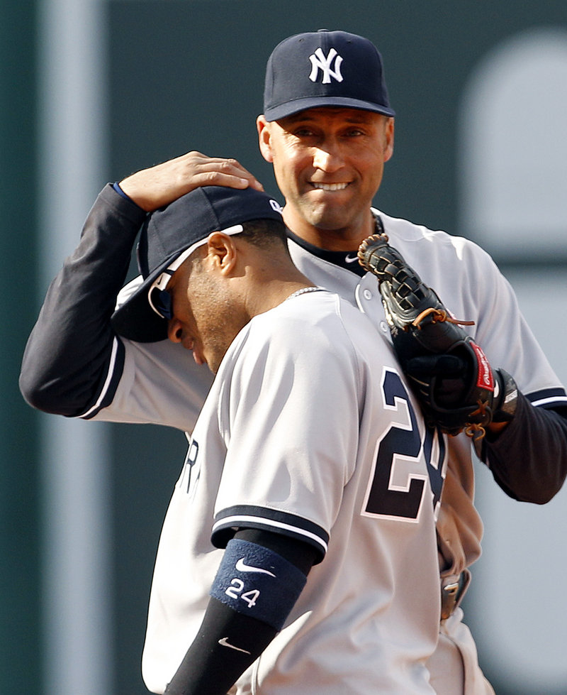 Robinson Cano, who continued his career-long torrid hitting in Fenway Park, receives a pat on the head from Derek Jeter after the New York Yankees came away with a 9-4 victory Saturday over the Red Sox.