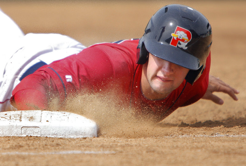 Portland's Alex Hassan dives back to first base in the third inning of the Sea Dogs against the Phillies on Sunday afternoon at Hadlock Field. Portland beat Reading 2-0 to close its season-opening series with 2 wins and 2 losses.