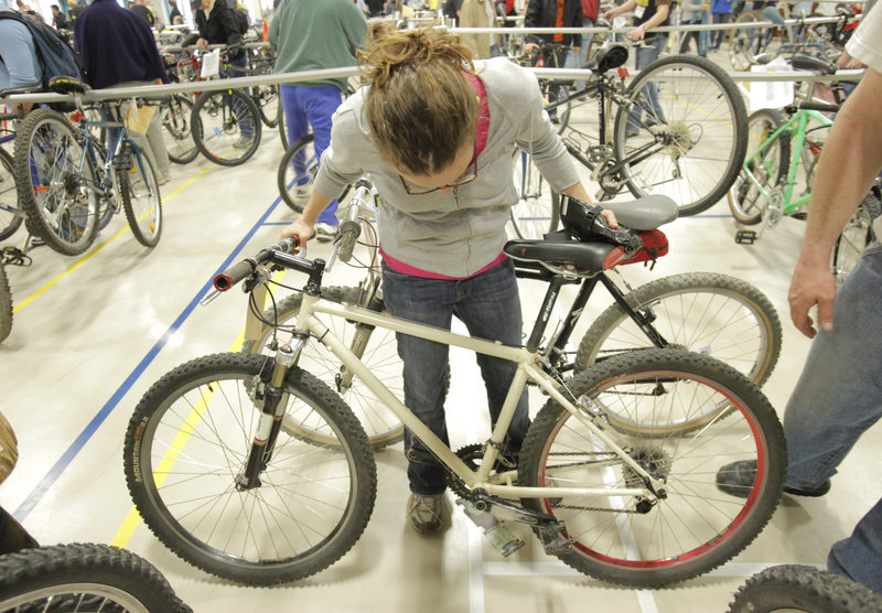 Emily Dornblaser of Portland checks out a bicycle at the Bicycle Coalition of Maine Bike Swap in Portland on Sunday. Dornblaser ended up purchasing the mountain bike.