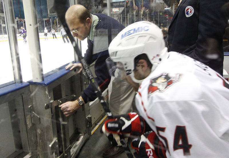 Ray Routhier opens the door for Portland Pirate Jacob Lagace after he served a penalty during Wednesday's game against the Manchester Monarchs.