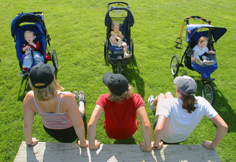 From their strollers, kids watch their moms do exercises during an organized workout at the downtown park in Bellevue, Wash. A study found that mothers of young children were heavier and ate more calories, sugary drinks and fatty foods than childless women.
