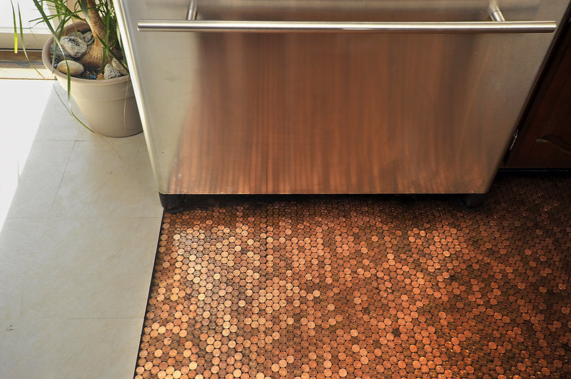 Edwards’ stainless-steel refrigerator reflects the rich coppery patina of the pennies she used to create her kitchen floor. “When the sun hits it just right, this floor just glows,” says Edwards.