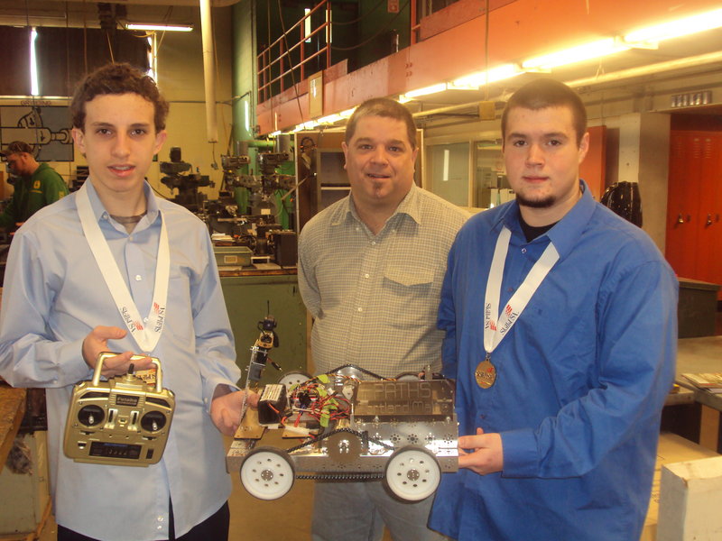 PATHS students Seth Guiod, left, and Devon Kelley, right, shown with teacher Joe Bolduc,won gold medals at a state competition for their robot.