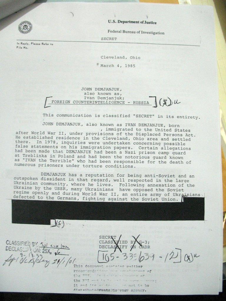 This picture, made at the U.S. National Archives in College Park, Md., on Feb. 25, shows a newly declassified, partially redacted FBI report on John Demjanjuk. In this 1985 report, the Cleveland FBI field office expressed serious doubts about evidence key to the current prosecution of John Demjanjuk on Nazi war crimes allegations, according to documents uncovered by The Associated Press, telling headquarters that Soviet intelligence might be duping the U.S. Department of Justice.