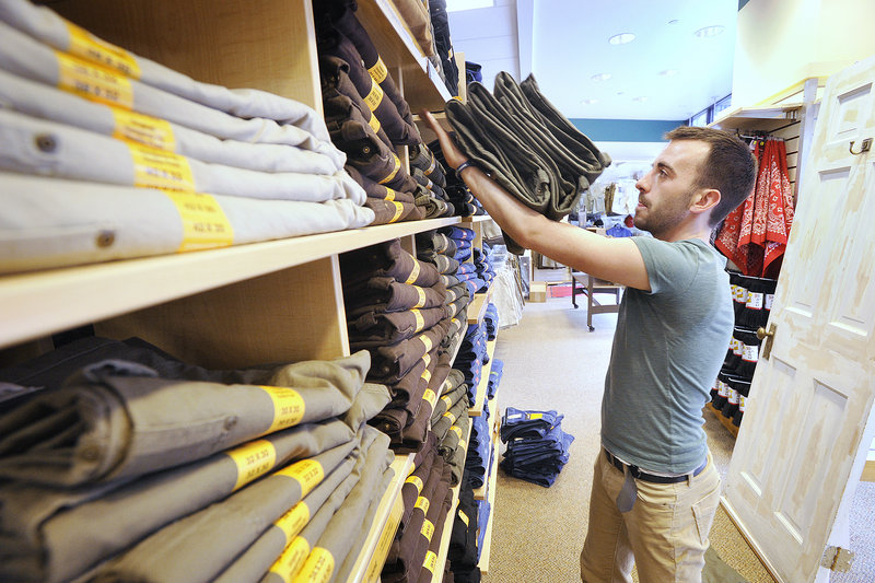 Renys employee Daniel Leaver stocks a display shelf Tuesday afternoon, as the new Congress Street location – the 14th Reny’s in Maine – readies for a 9 a.m. opening on Thursday.