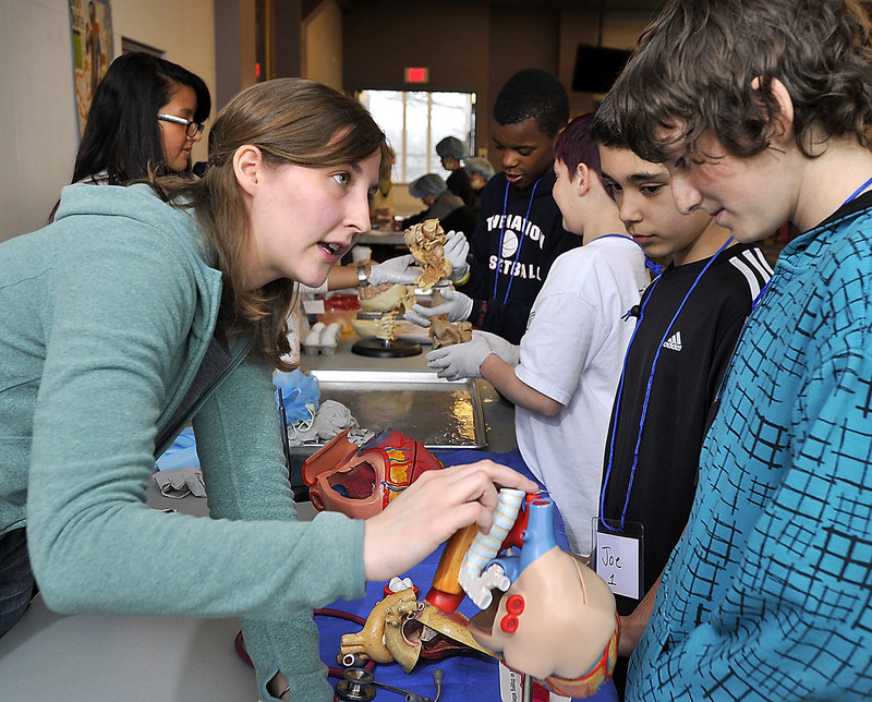 First-year medical student Lauren Jamele, left, uses a model to point out the parts of the human heart to Biddeford students Joe Balzano, 11, and Chad Sweeney, 12, on Wednesday.
