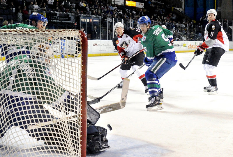 Connecticut goalie Dov Grumet-Morris blocks a shot as the Whale’s Brodie Dupont, right, and Portland’s Dennis Persson look on during Portland’s 3-2 playoff win.
