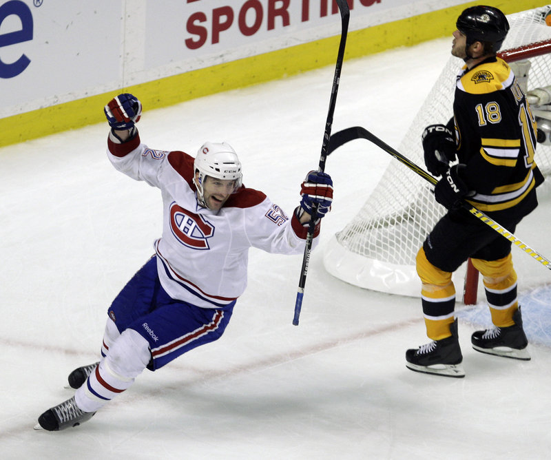 Mathieu Darche skates past Boston’s Nathan Horton while celebrating the second goal by Brian Gionta. The Canadiens took a 1-0 lead in the best-of-seven series.