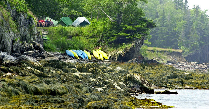 Kayakers from Venture Crew, a senior scouting group, set up camp on Casco Bay’s Jewell Island, the most popular stop on the Maine Island Trail. State money contributed to the group that operates the trail is used in part to fund a summer caretaker on the island.