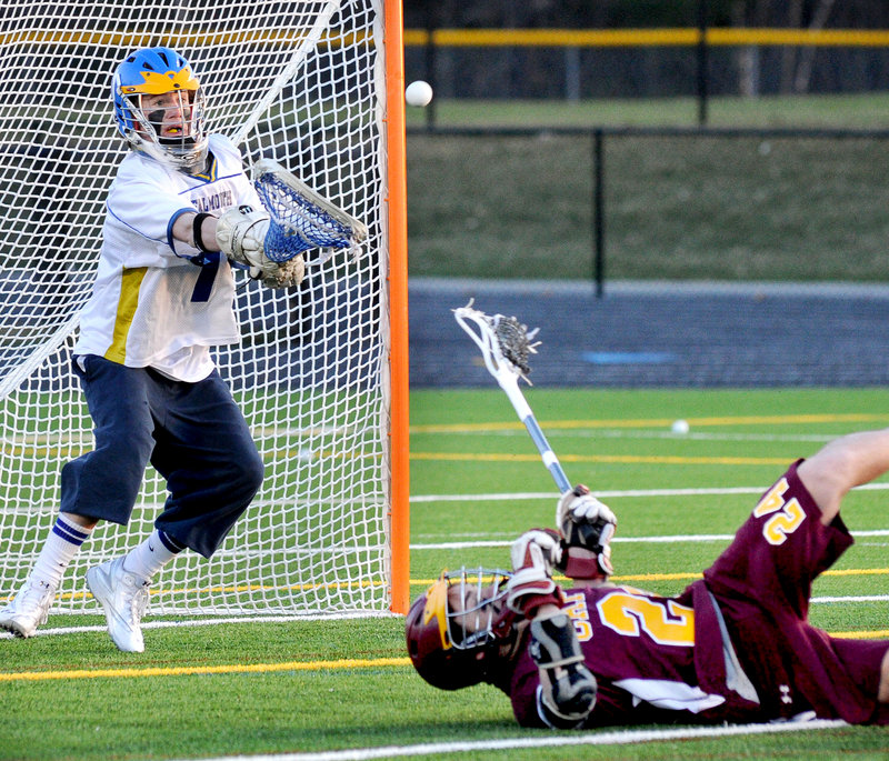 Falmouth goalie Cam Bell focuses on making a save against Wes Richards of Cape Elizabeth, who fell after taking a shot during their schoolboy lacrosse game Friday at Falmouth High. Falmouth won, 12-4.