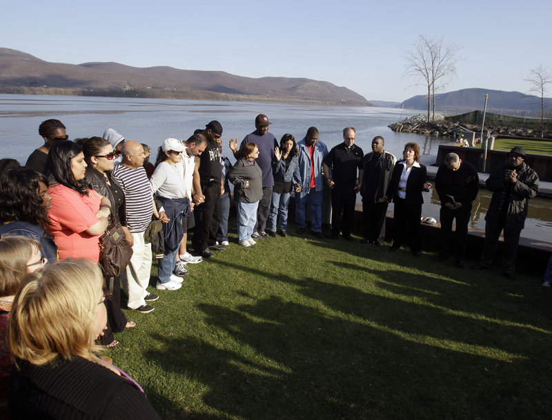 People attend a vigil on Thursday at the boat ramp In Newburgh, N.Y., where Lashanda Armstrong drove her minivan into the Hudson River on Tuesday night, killing herself and three of her children.