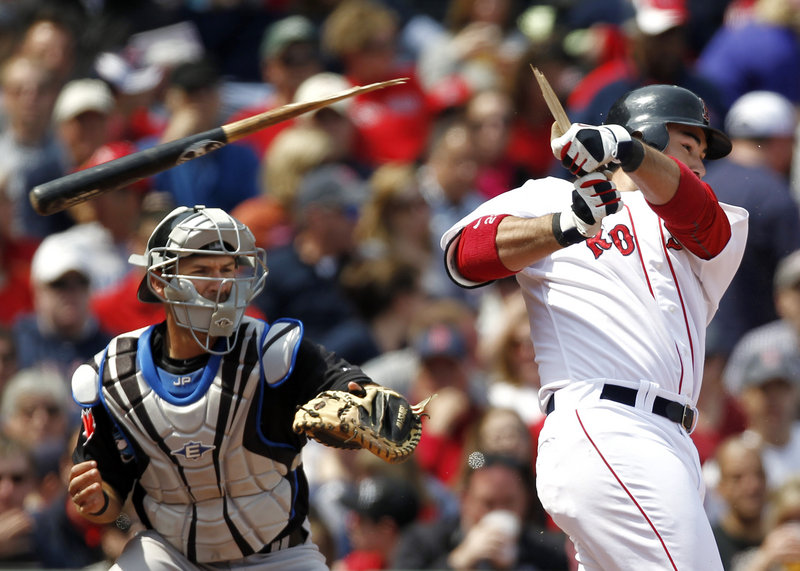 Boston’s Adrian Gonzalez shatters his bat on a ground out as Toronto catcher J.P. Arencibia looks on during the sixth inning of Boston’s 9-1 win Monday at Fenway Park. The Sox rapped out 13 hits and three home runs against the Blue Jays.