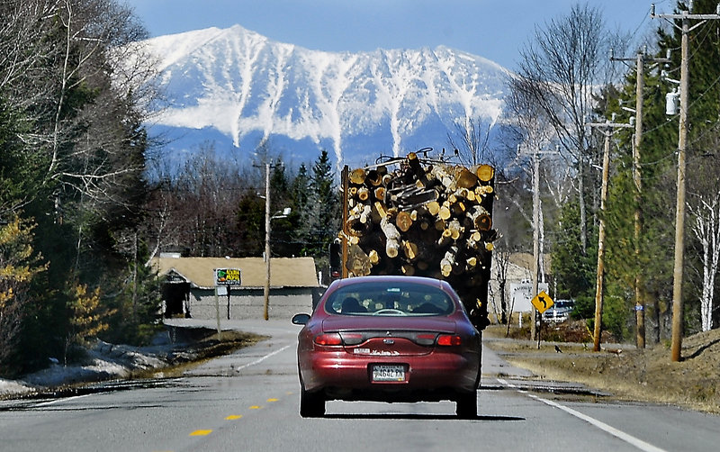 Mount Katahdin looms in the distance as a truck carries logs to a logging yard in Millinocket in 2014. On Saturday, close to 1,000 runners are expected for an unusual road race that aims to help the struggling mill town.