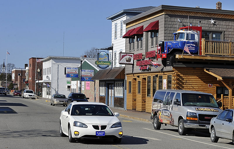 Pedestrians walk past the new Blue Ox Saloon East establishment in downtown East Millinocket, one of the few new businesses in the struggling milltown.
