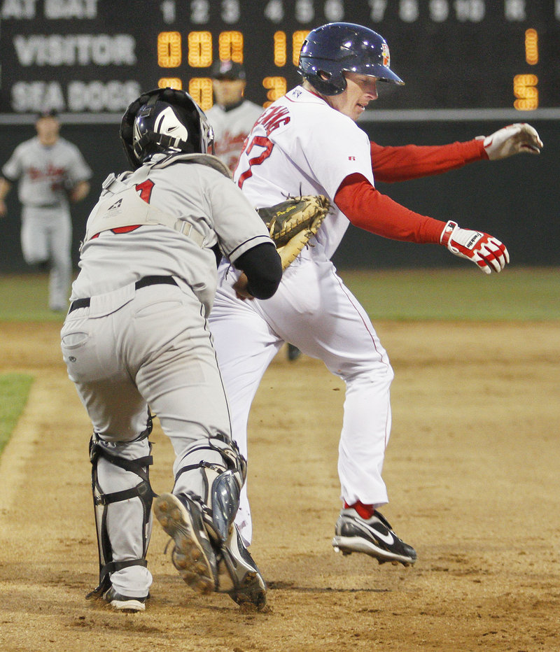 Rock Cats catcher Allan de San Miguel tags out Mitch Dening of the Sea Dogs after a rundown between first and second during a game Thursday night at Hadlock Field. Portland opened a seven-game homestand with a 5-1 win.
