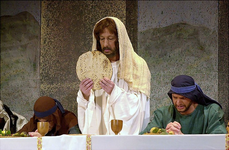 Jesus, portrayed by Gary Schalhoub, breaks bread during the Last Supper scene in the Passion play – a re-enactment of the trials, crucifixion and resurrection of Jesus Christ – at Park Theatre in Union City, N.J., on March 25, 2004. A British researcher believes that the supper did not take place on a Thursday, as it is celebrated by Christians around the world.