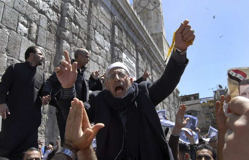 A government supporter shouts slogans during a demonstration Friday outside the Omayyad mosque in Damascus, Syria. Thousands of anti-government protesters demonstrated elsewhere, demanding reforms beyond the limited concessions offered by President Bashar Assad.