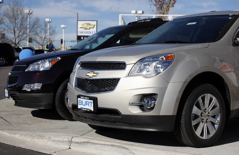 A 2010 Chevrolet Traverse, left, and 2010 Equinox sit at a dealership in Englewood, Colo. GM came within 30,000 sales of Toyota last year.