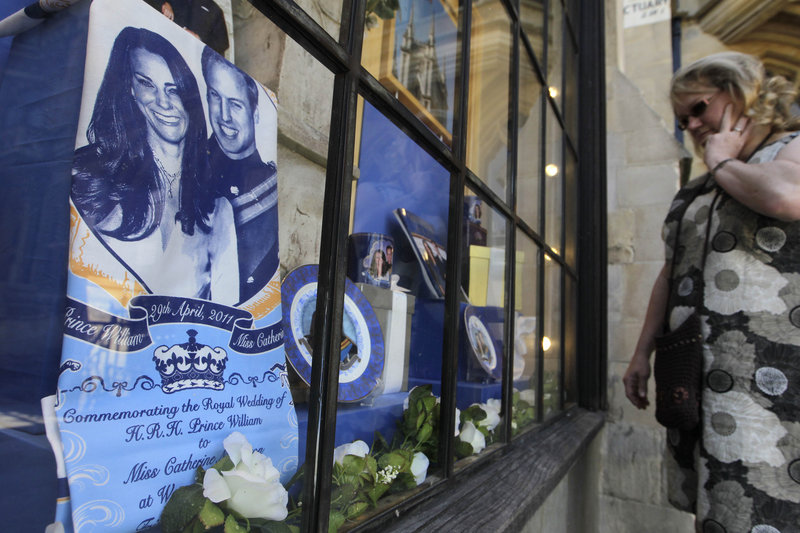 A passer-by checks out a display of souvenirs of Prince William and Kate Middleton in a Westminster Abbey shop window in London on Friday. The couple are to marry April 29 at Westminster Abbey.