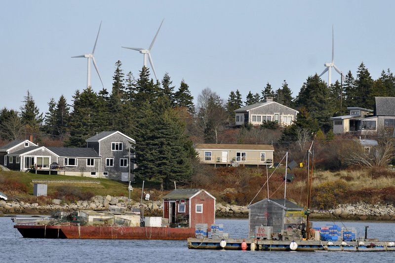 Vinalhaven’s wind turbines overlook an iconic Maine scene, but such a presence devalues local properties, critics say.