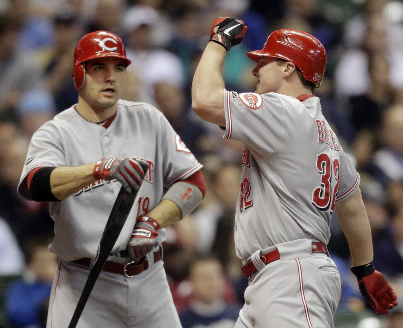 Jay Bruce, right, is congratulated by teammate Joey Votto after Bruce hit a two-run home run during the third inning in Milwaukee. The Reds scored six runs in the inning.