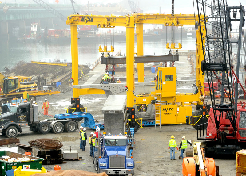 A travel lift unloads large precast concrete bridge segments at the site of the new bridge over the Fore River in Portland. The old bridge will remain open during the construction process, which is expected to last into the summer of 2012.
