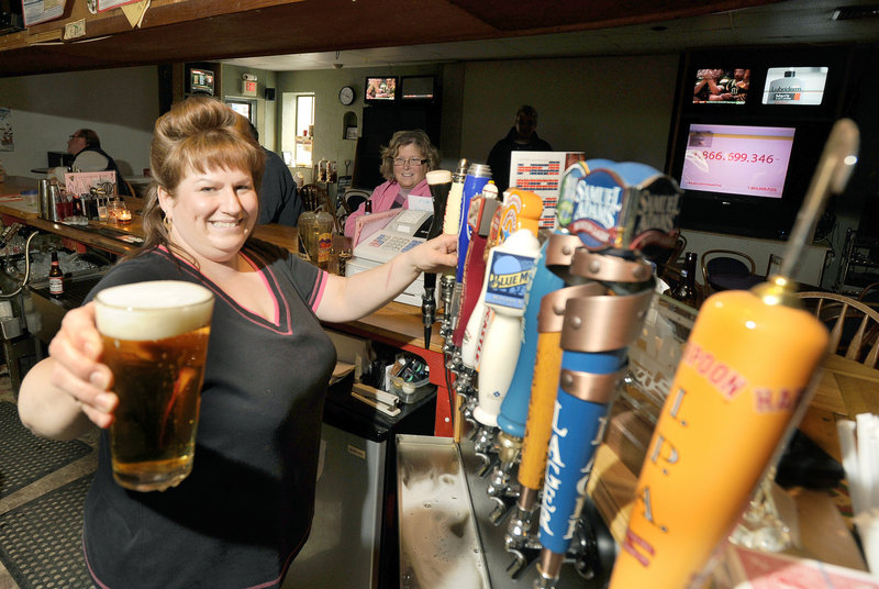 Bartender Sue Hanna pours a draft beer at Spectators Sports Bar in Sanford. The full bar has almost 60 kinds of beer, affordable food, plenty of games, a variety of live entertainment and 13 TVs.