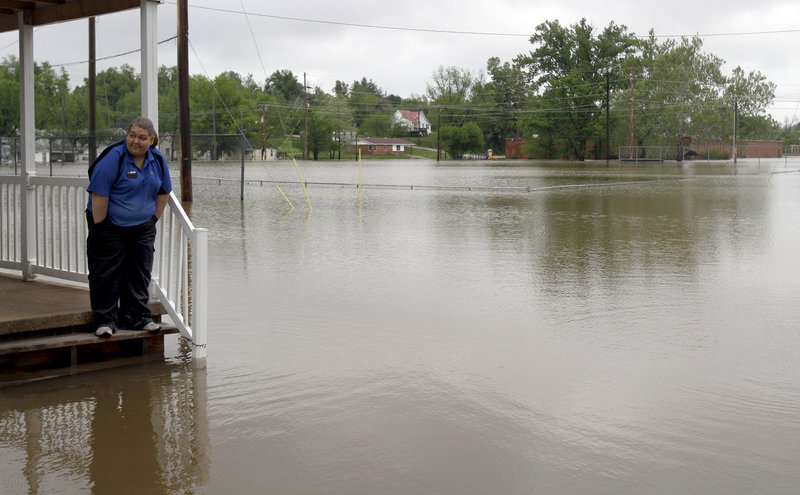 Erica Cross stands on a friend’s porch surrounded by floodwater Tuesday in Poplar Bluff, Mo, where 6 inches of rain fell Monday alone, bringing the four-day total to 15 inches.