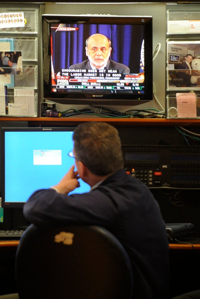 Sean Spain of Goldman Sachs watches Ben Bernanke on television Wednesday from the New York Stock Exchange. It was the first time in the Fed’s 98-year history that a chairman has begun holding regular sessions with reporters.