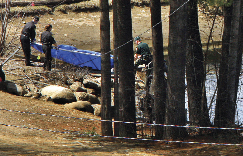 Police carry a blue tarp Wednesday from a pond at Cranmore Mountain Resort in North Conway. Police searched the pond while investigating the disappearance of Krista Dittmeyer, whose car was found nearby Saturday with the engine running and her daughter inside.