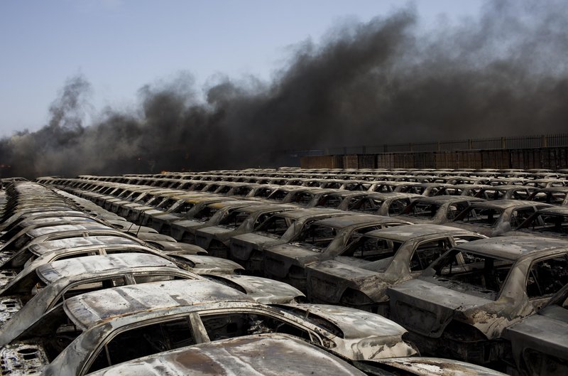 Black smoke drifts over rows of burned cars at the port of Misrata, Libya, Wednesday. The port was quiet after fierce bombardment and attacks the day before.