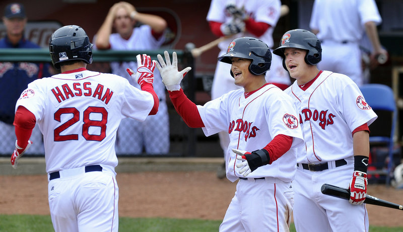 Alex Hassan is welcomed by Che-Hsuan Lin, center, and Ryan Lavarnway after hitting one of the Portland Sea Dogs’ five home runs Thursday in a 12-5 victory against the Binghamton Mets at Hadlock Field. Hassan is batting .439.