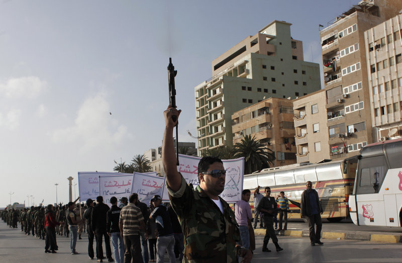 A Libyan rebel fires his machine gun in the air during a military parade Wednesday in Benghazi, Libya. Participants called for more Western arms for the anti-Gadhafi revolution but rejected intervention on the ground by foreign troops.