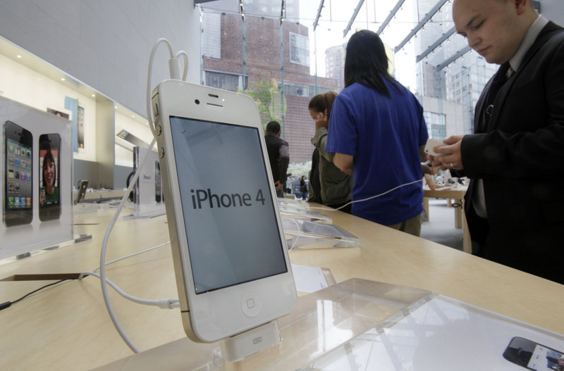 A customer examines an iPhone, a key product in Apple’s success story, at the Apple store in New York City on Thursday.