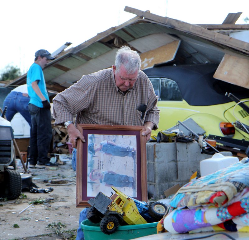 Ken Carter, 74, retrieves a few salvageable belongings Thursday from his home in Apison, Tenn. He tried to get out of the house when the storm struck, but was thrown into the yard when the tornado blew out a wall.