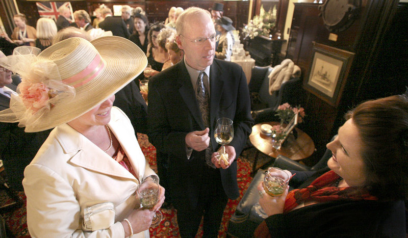 Jo Harrison of Brunswick, left, and her husband, Leigh, visit with Cecille Tetrev of Woolwich during a black tie formal party to celebrate the royal wedding at the Cumberland Club in Portland on Friday. Props included magazines and books on the British royals, and a giant poster with pictures of past monarchs and their offspring.