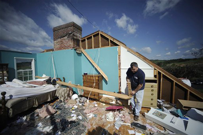 Shane Gilland sorts through the wreckage of his father's home in Bethel, Va., today. Gilland's father and stepmother Gail survived when a tornado hit their house early Thursday.