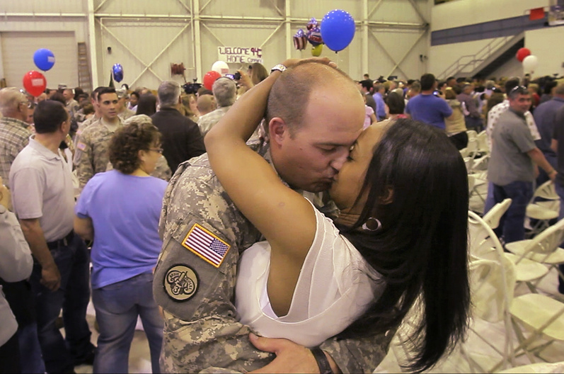 Sgt. Justin Titcomb of Wells and his wife, Joana, embrace Tuesday in Manchester, N.H. Titcomb, a Wells policeofficer, spent a year serving in Baghdad with the 94th Military Police Company.