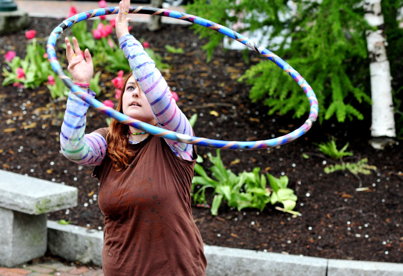 Kerri Consiglio of Windham twirls an “exercise hoop” made with irrigation tubing and filled with water while hanging out Monday at Post Office Park in Portland.